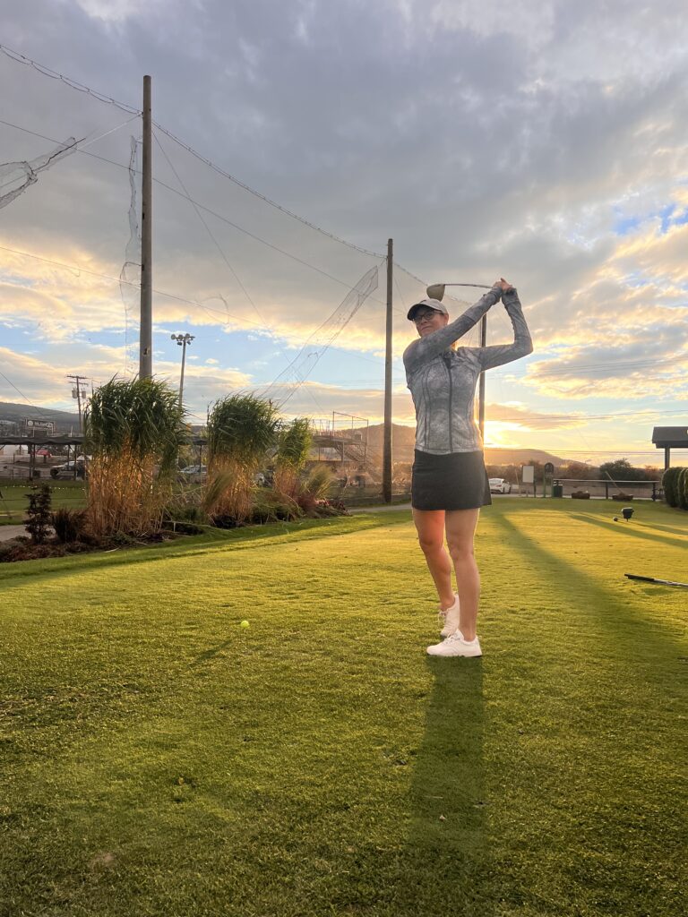 Lisa Moonie practicing swinging on a golfball 